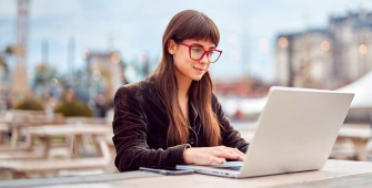 Jeune entrepreneuse devant son ordinateur (article sur la création d'entreprise)