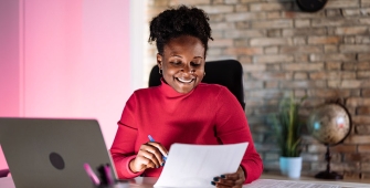 Commerçante à son bureau tenant une feuille
