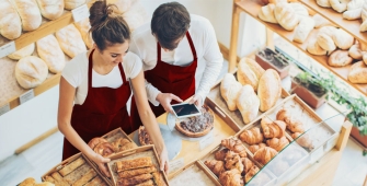 Couple de boulanger devant des pains et des croissants (article sur la reconversion professionnelle)