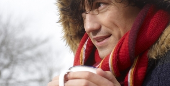 Un homme qui boit une boisson chaude en doudoune