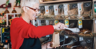 Une femme dans un magasin qui se sert dans des produits vracs