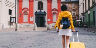 Une jeune fille avec sa valise jaune part faire ses études à l'étranger