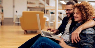 Un couple compare sur Internet des assurances de prêt immobilier