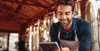 Commerçant dans sa boutique regardant son ipad