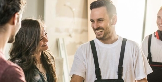 Groupe d'artisans discutant d'un projet de rénovation énergétique avec une cheffe d'entreprise