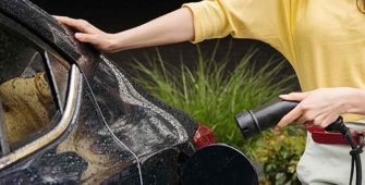 Une femme qui charge sa voiture électrique sur une borne