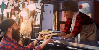 un homme récupère son repas dans un foodtruck