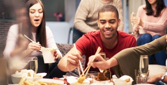 Groupe d'amis sur un canapé dégustant un repas ensemble