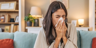 Une femme qui se mouche dans son salon