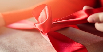 Une main qui ouvre un ruban de cadeau