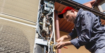 Un installateur de pompe à chaleur devant une maison