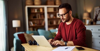 Un homme chez lui devant son ordinateur