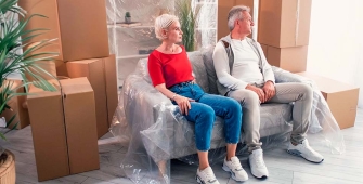 Un couple assis dans un salon rempli de cartons