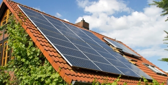 Maison en bois dont le toit est recouvert de panneaux solaires