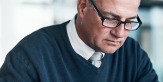 homme à son bureau en pleine réflexion