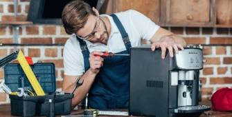 Réparateur en train de réparer une cafetière électrique