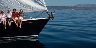 Groupe d'amis assis sur le pont d'un voilier en mer