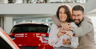 Jeune couple achetant une voiture rouge