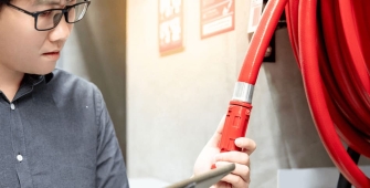 un homme devant une lance à incendie