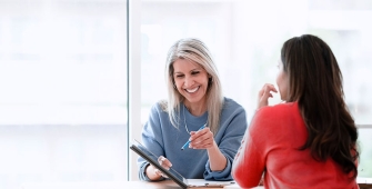 Deux femmes en train d'échanger devant une tablette
