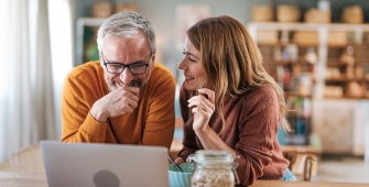 un homme et une femme devant leur PC