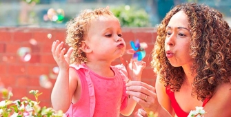 Une mère et sa fille qui soufflent des bulles