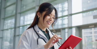Une femme médecin regarde sa tablette numérique rouge