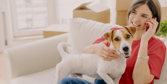 chiot blanc et sa maîtresse sur le canapé dans un appartement
