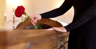 Une femme qui dépose une rose sur un cercueil 