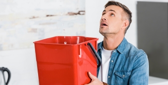 homme tenant un seau en direction du plafond