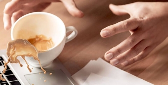 Une personne qui renverse un café sur un ordinateur