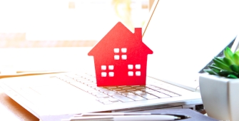 Illustration d'une maison rouge posée sur un ordinateur portable