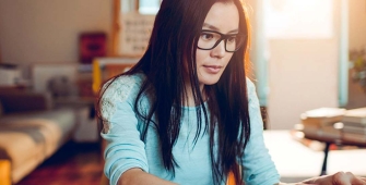 Une femme qui consulte son ordinateur dans son salon
