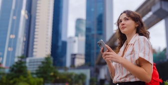 Jeune femme devant des tours de bureau à l'étranger