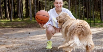Une femme qui joue au basket avec son chien