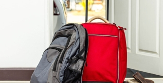 Un sac et une valise posés devant une porte