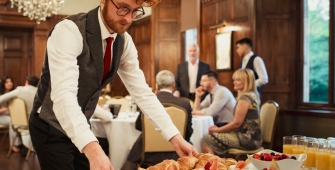 Serveur dressant une table dans un salon de réception