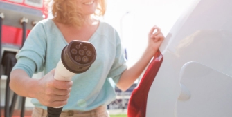 Une femme qui recharge sa voiture électrique