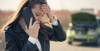 Une jeune femme soucieuse à cause d'une panne auto