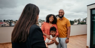 Une famille sur une terrasse avec un agent immobilier