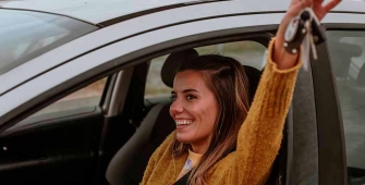 Une femme au volant qui sort ses clés 