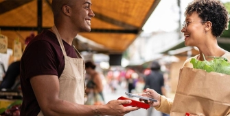 Un commerçant et une cliente échangent sur un marché ambulant