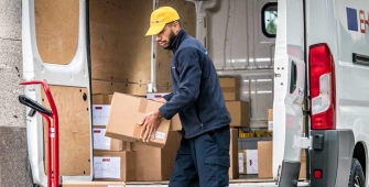 Un transporteur range des colis dans sa camionnette