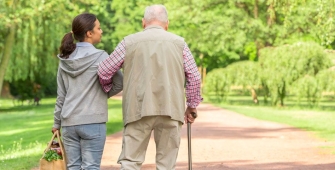 homme senior se promenant avec son aidante