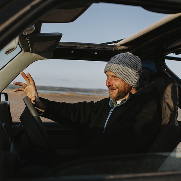 un homme dans sa voiture près de la plage