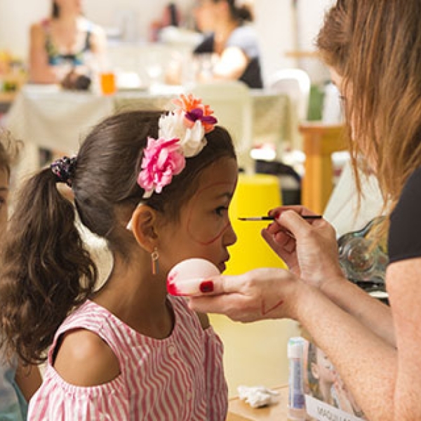 Une femme qui maquille une enfant