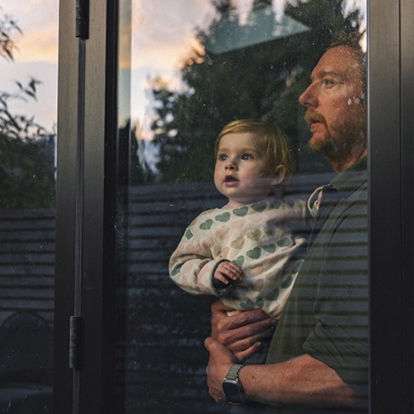 Un père et son bébé regardent par la fenêtre