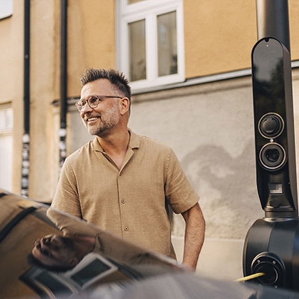 Automobiliste rechargeant sa voiture électrique à une borne