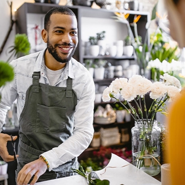 Jeune fleuriste parlant à une cliente