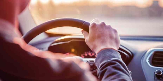Un homme tient le volant de sa voiture